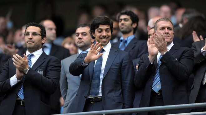 Sheikh Mansour saluda en el palco durante un partido del City.