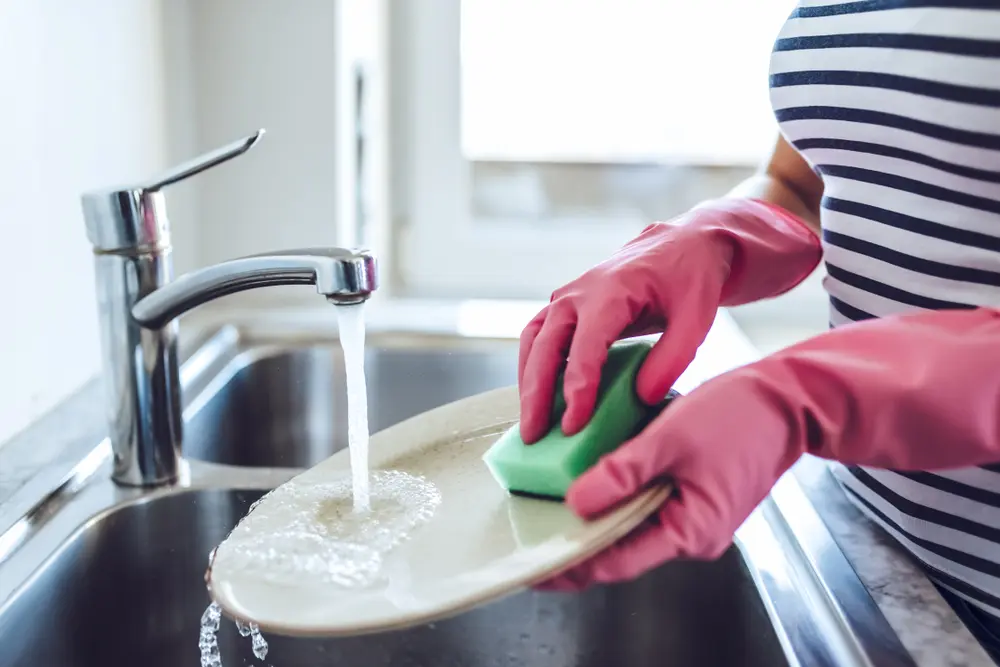 Se recomienda usar guantes cuando laves los platos con agua caliente.
