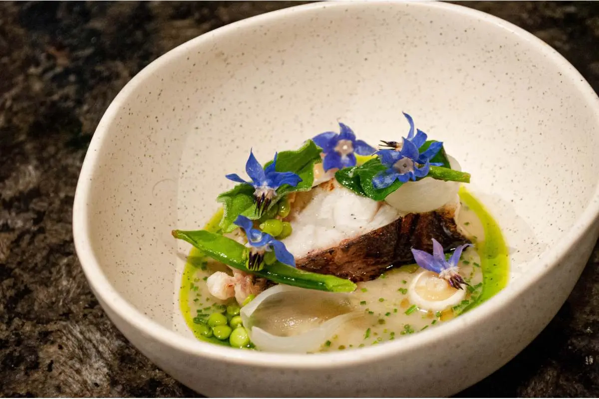 Lobina madurada con salsa de amazake y curry verde, decorada con emulsión de salicornia, del chef Joaquín Esquivel, originario de Guanajuato, se sumó al menú de aniversario.