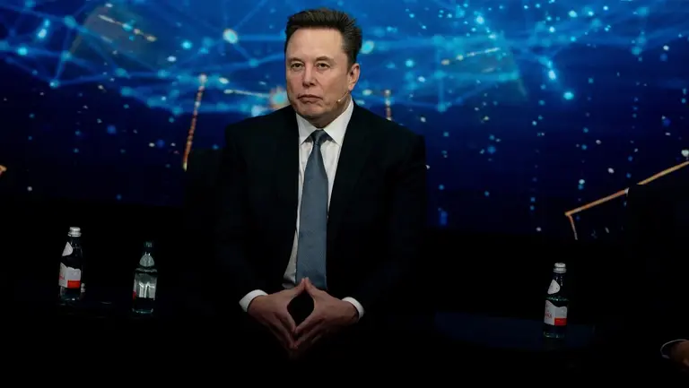 Elon Musk vestido con saco y corbata en un escenario