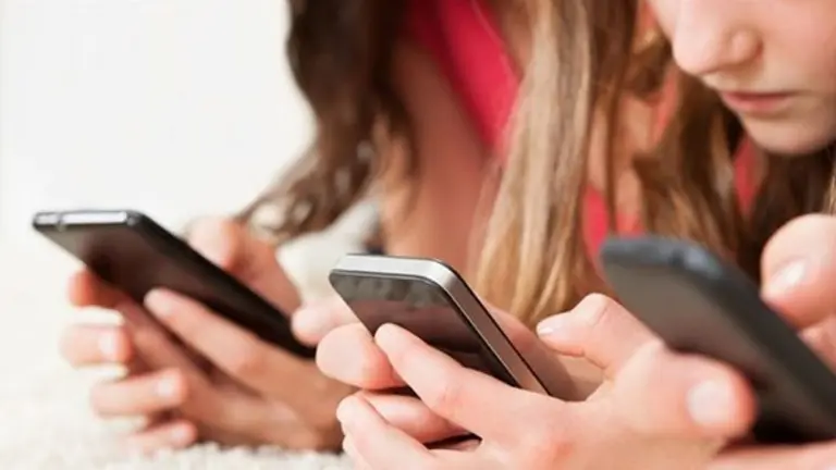 Chicos menores mirando el celular